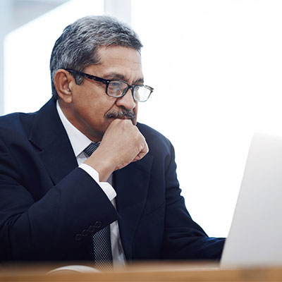 financial advisor reviewing reports on computer